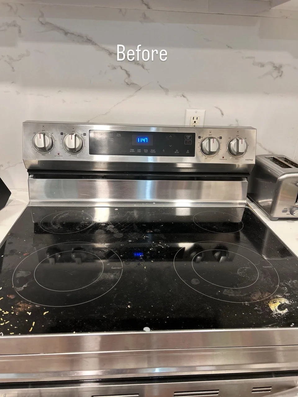 Food residue and marks on a black glass-top range before cleaning